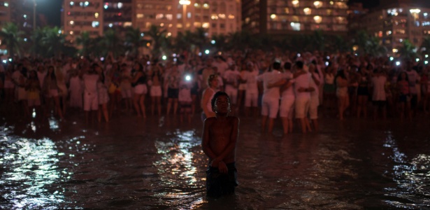 1jan2018---menino-entra-no-mar-enquanto-pessoas-de-abracam-durante-as-celebracoes-de-ano-novo-na-praia-de-copacabana-na-zona-sul-do-rio-de-janeiro-1514910748877_615x300